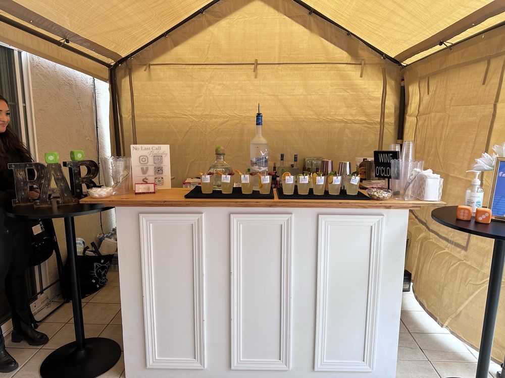 Adina smiling behind a lit bar setup during an evening event